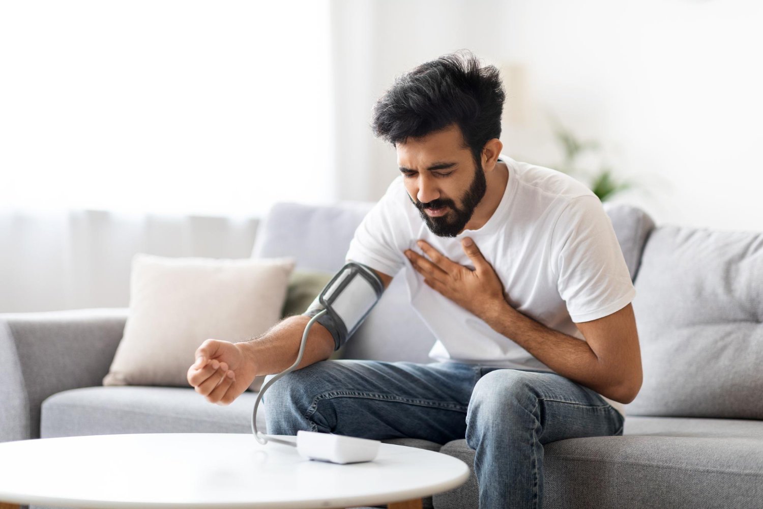 Man checking his pulse after experiencing an irregular heartbeat, an early warning sign of heart disease.
